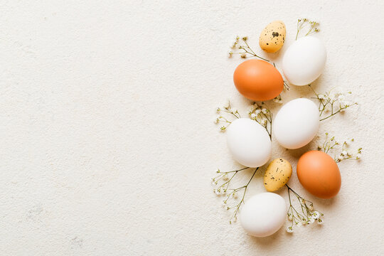 Happy Easter composition. Easter eggs on colored table with gypsophila. Natural dyed colorful eggs background top view with copy space - Powered by Adobe