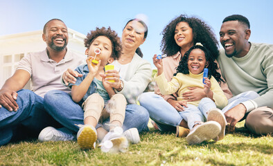 Family, happiness outdoor and relax on lawn, kids blowing bubbles together with grandparents and parents. Happy people, summer and sitting on grass, love and care, bonding with generations and smile