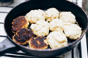 Raw pork cutlets are fried in an old soviet frying pan.