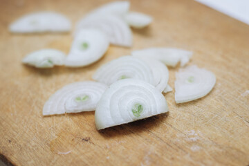 Onion finely chopped into slices on a wooden board