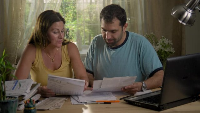 Worried adult couple looking at financial paperwork