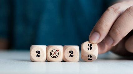 wooden block indicates year 2023 and target icon.