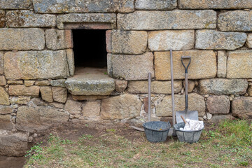 tools next to an ancient granite stone wall in an archaeological excavation
