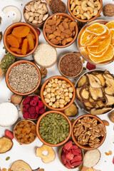 Healthy vegetarian food concept. Assortment of dried fruits, nuts and seeds on white background. Top view. Mixed nuts set closeup.