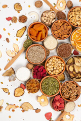 Healthy vegetarian food concept. Assortment of dried fruits, nuts and seeds on white background. Top view. Mixed nuts set closeup.