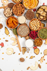 Healthy vegetarian food concept. Assortment of dried fruits, nuts and seeds on white background. Top view.