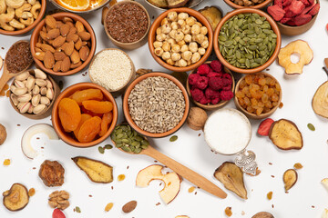 Healthy vegetarian food concept. Assortment of dried fruits, nuts and seeds on white background. Top view. Mixed nuts set closeup.