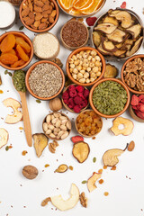 Healthy vegetarian food concept. Assortment of dried fruits, nuts and seeds on white background. Top view. Mixed nuts set closeup.