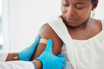 Healthcare, plaster and doctor helping a patient after an injection or vaccine in the hospital. Consultation, appointment and hands of medical worker putting a bandaid on a woman in a medicare clinic