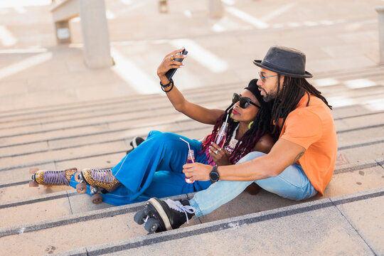 Cheerful couple with roller skating outside. Fun sexy boyfriend and girlfriend taking selfie photo.