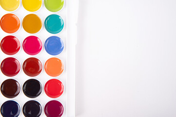 Box with watercolor paint on white background, background. Equipment for a creative hobby - drawing.