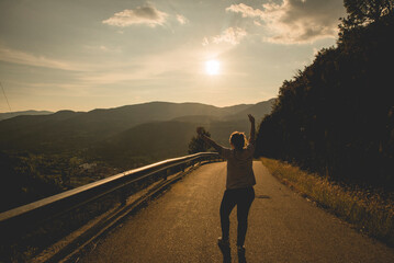 Chica en el medio de la carretera celebrando la libertad y relajada