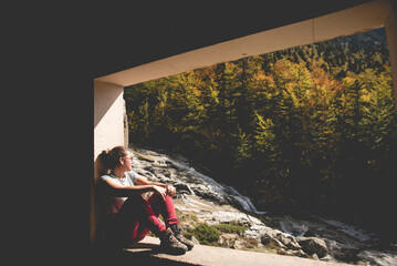 Chica sentada descanso en una excursión con un paisaje de cascada 