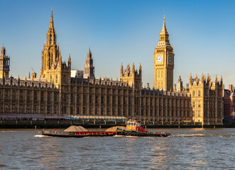 Fototapeta premium Big Ben and the River Thames with a blue sky and warm sunshine