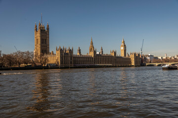 Fototapeta na wymiar Big Ben and the River Thames with a blue sky and warm sunshine