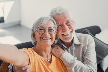 Head shot portrait happy senior couple taking selfie, having fun with phone cam, smiling aged wife and husband hugging, looking at camera, posing for photo, aged man vlogger recording video.