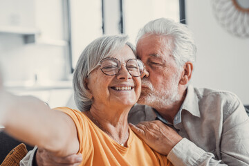 Head shot portrait happy senior couple taking selfie, having fun with phone cam, smiling aged wife and husband hugging, looking at camera, posing for photo, aged man vlogger recording video.
