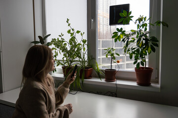 Woman cleaning windows at home with robotic cleaner.
