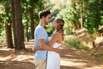 Happy couple, hug and outdoor forest road of young people showing love for engagement announcement....
