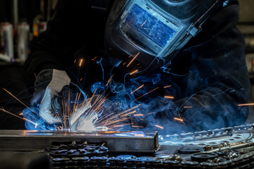 Welder is welding metal, artistic welding sparks light