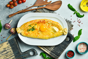 Traditional azerbaijan cuisine: Khachapuri with cheese, egg and butter. Free space for text. On a dark background.