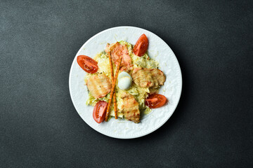 Traditional Caesar salad with chicken. Close-up, dark background.