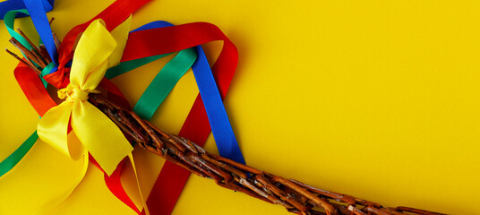 Easter braided whip, traditional symbol of Czech and Slovak Easter. Close up of Easter handmade whip with colorful ribbons on yellow background. Top view with copy space © KatuSka