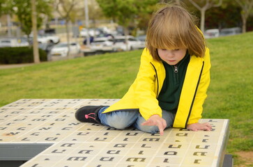 Little boy looks up the Hebrew alphabet. Learning with play. Hebrew letters. Learning Hebrew for...