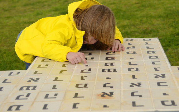 Little boy looks up the Hebrew alphabet. Learning with play. Hebrew letters. Learning Hebrew for kids.