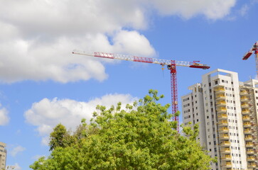 Fototapeta premium Construction site, construction crane. New building in Israel. Concept: real estate agency, apartment on credit, real estate investment. Modern white residential building