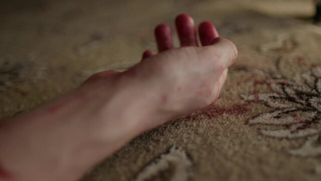 Close up of white male murdered hand falling to the floor
