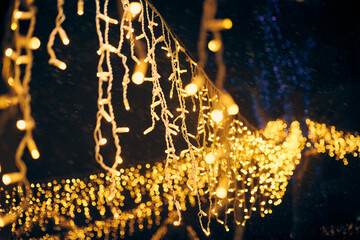 Yellow lights bokeh from christmas holiday garlands, blurred festive background, abstract outdoor...