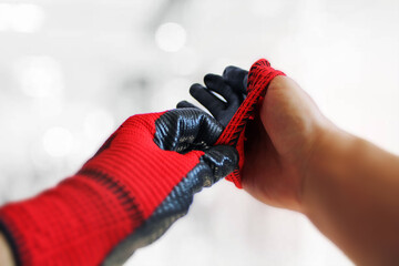Two hands wearing red work gloves isolated.