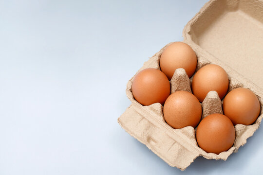 Chicken eggs in a cardboard box ready to cook on the table in the kitchen