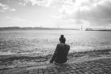 imagen de soledad con una chica y el puente rojo de lisboa en el fondo 
