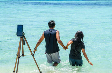 Indian couple taking pictures to the sea