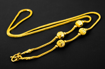 Fototapeta na wymiar The gold necklace on a black background.