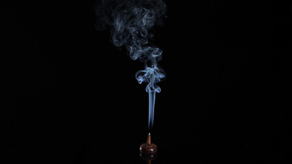 real incense cone burning with intense and soft smoke on dark background, meditation and relaxation...