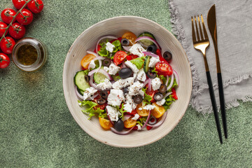 Greek salad of fresh cucumber, tomato, sweet pepper, arugula, red onion, feta cheese and olives with olive oil. Healthy food. Top view