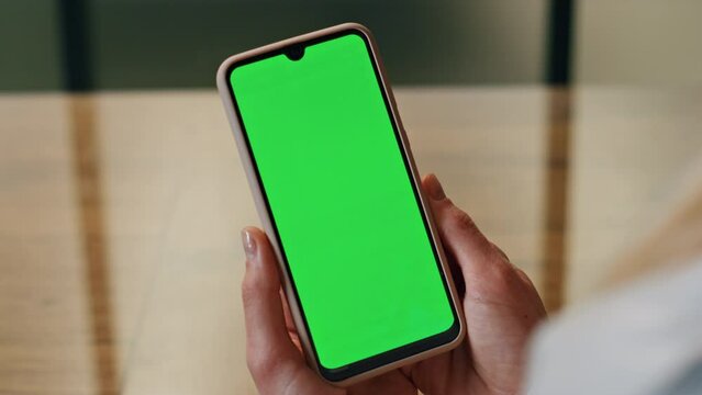 Lady looking green display phone close up. Woman hands holding mockup cellphone