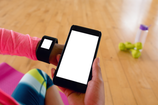 Woman holding mobile hone while using smartwatch