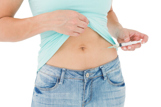 Woman injecting fluid in her stomach