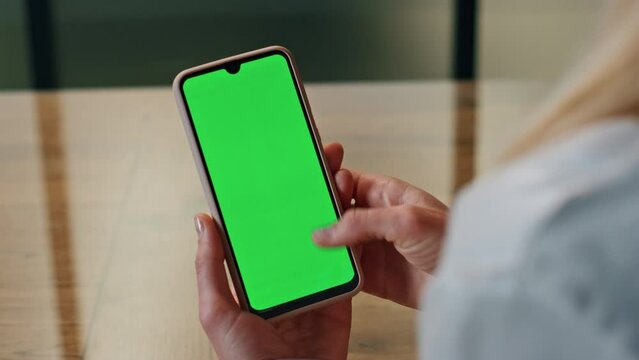 Woman hand scrolling green phone screen indoor closeup. Lady reading cellphone