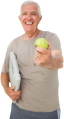 Cheerful senior man with an apple and scales