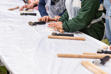 Kids cooking, roll out the dough and making matzah for Jewish holiday Passover Pesach at culinary master class for children outdoor in park. 