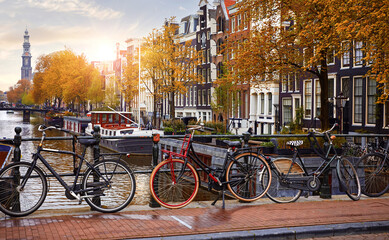 Bike over canal Amsterdam city autumn yellow leaf fall. Picturesque town landscape in Netherlands with view on river Amstel