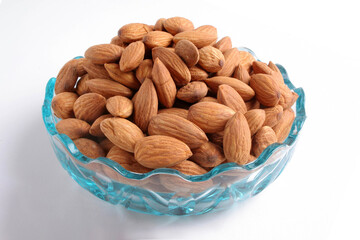 Glass bowl with almonds isolated on white background