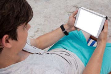 Man using digital tablet on the beach