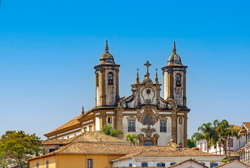 Fototapeta na wymiar Historic church and its towers rising from among the colonial-style houses in the city of Ouro Preto in the state of Minas Gerais