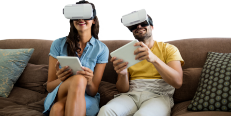 Smiling Couple wearing virtual reality glasses while using digital tablets on sofa